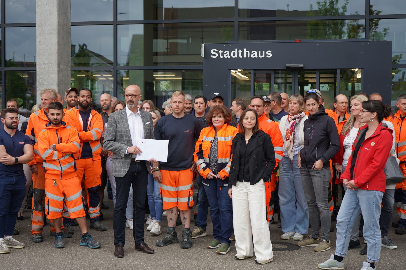 Viele Menschen stehen vor einem Haus. 